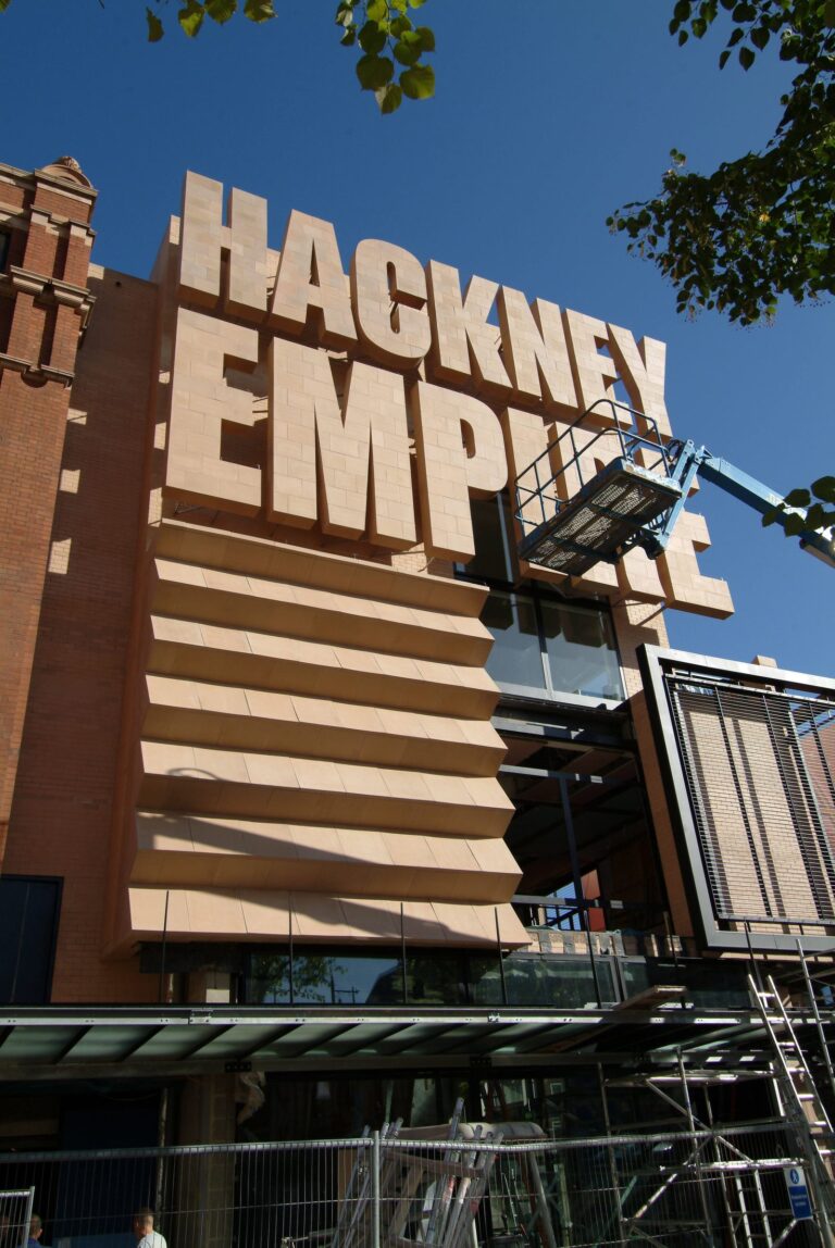 The sandstone-cut Hackney Empire lettering on the theatre's modern extension on Mare Street, picked out against a clear blue sky